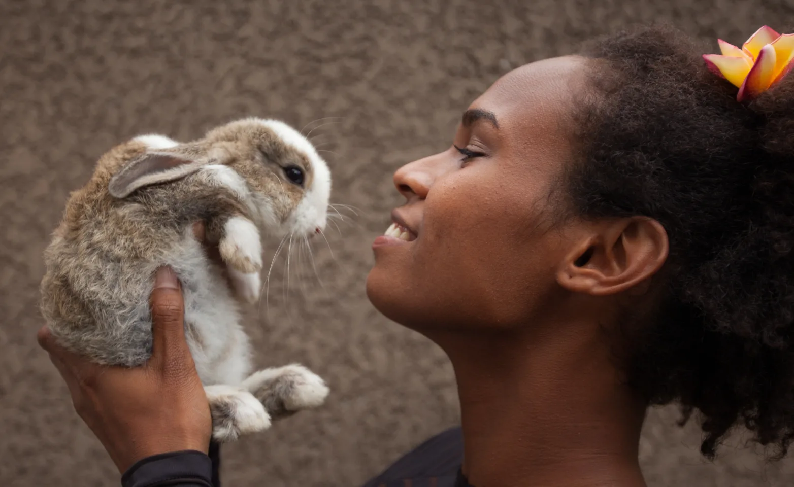 Woman holding rabbit up close